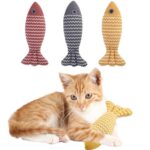 A cat cuddling with a yellow striped plush fish toy.