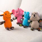 Four plush floral animal cat toys lined up on sofa